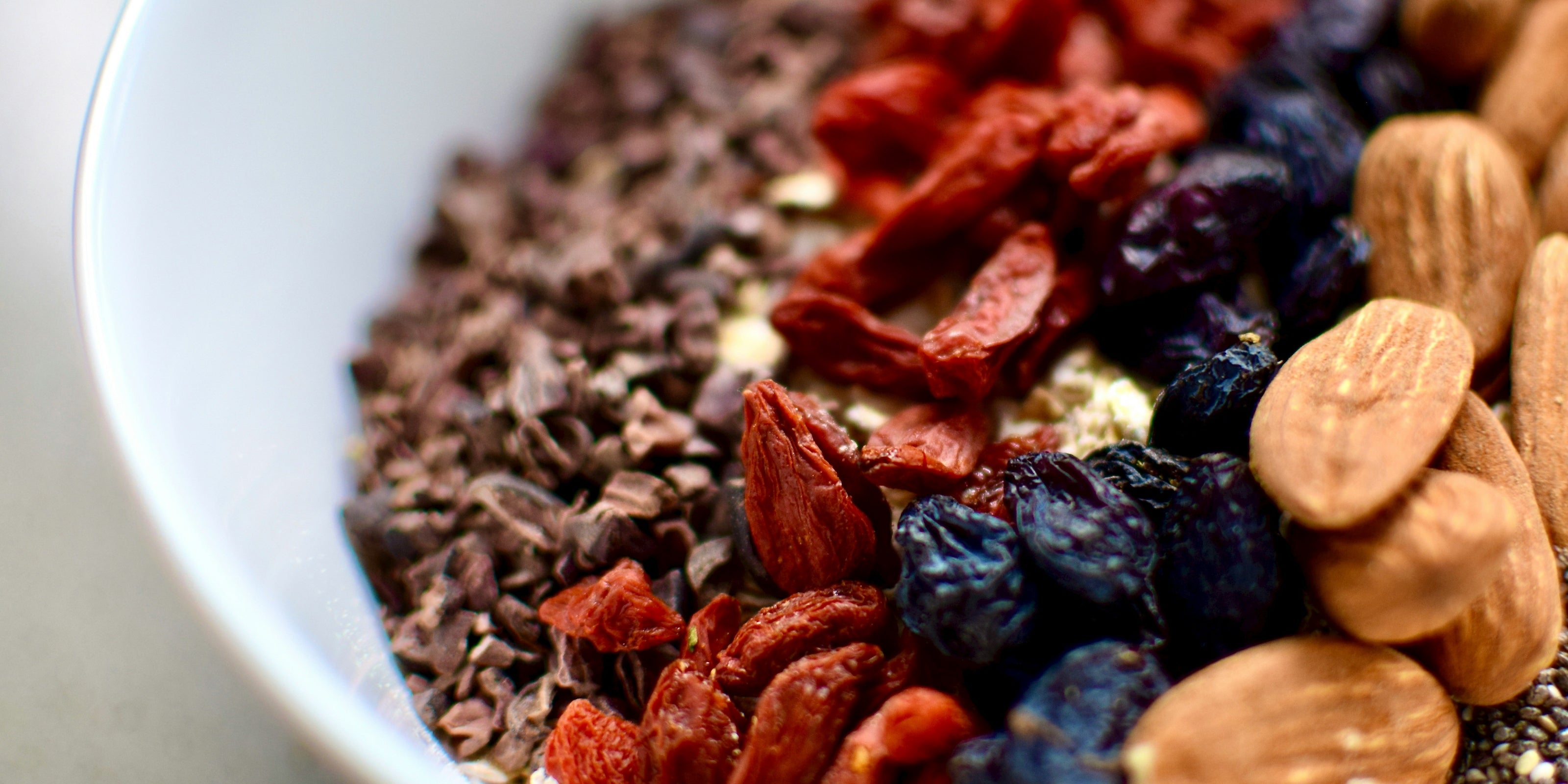 Skin Longevity, Nahaufnahme Schale mit Nüssen Trockenfrüchten und Müsli, HEJ ORGANIC